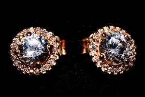 elegante diamante pendientes con oro ajuste en un negro antecedentes. foto