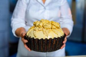 Fresh delicious cake in female baker hands. Tasty crusty bakery food. photo