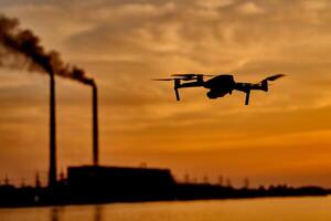 drone silhouette against the background of the sunset. Flying drone in the evening sky photo