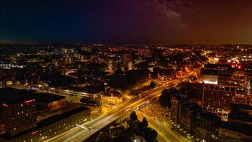 noche paisaje urbano con iluminado calles y urbano horizonte debajo un estrellado cielo en leeds. foto