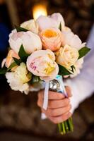 Beautiful bouquet with delicate flowers. Wedding flowers. Bridal bouquet in male hands photo