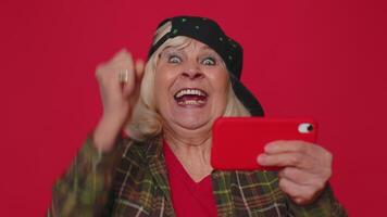 preoccupato divertente dipendente anziano donna con entusiasmo giocare guidare da corsa video Giochi su mobile Telefono