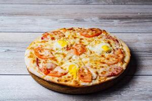 Tasty pizza on table. Delicious pizza served on wooden plate photo