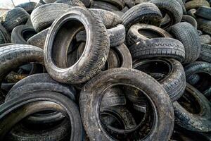 Garbage heap ready for disposal. Old worn out tires on an abandoned trash dump photo