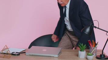 Smiling mature business man sits at workplace office desk, opening laptop computer, start working video