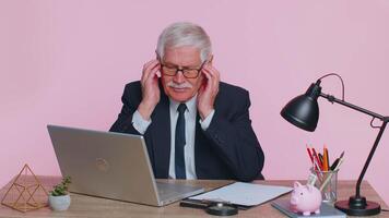 Displeased senior business man rubbing temples to cure headache problem, suffering from migraine video