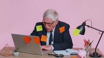 Tired exhausted senior business man office manager with laptop sticky notes sticks with many tasks video