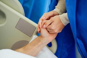 Holding patient hands in a hospital. Family help. Closeup. Support. photo