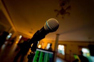 Microphone on the blurred background. Close-up microphone in the concert hall blur background. Musical concept photo