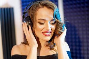 Portrait of young beautiful woman with headphones listening to music. Attractive happy female model isolated in studio. Happiness concept. photo