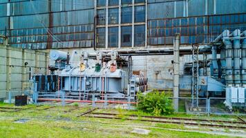 Part of an old electric power plant outside. Backside of a big power plant in summer. photo