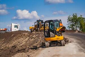 Tractor, roller on the road repair site. Road construction equipment. Road repair concept. Construction workers on road repair. photo