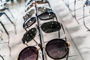 Sunglasses in a store. Row of luxury eyeglass at an opticians store photo