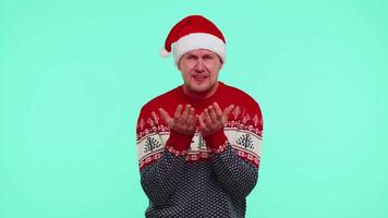 Upset disappointed man in red New Year sweater wipes tears and cries from despair not received gift video