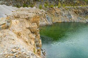 flooded pit mining or quarry with beautiful blue water. Side view panoramic photo. photo