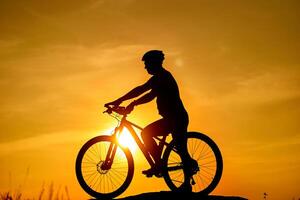 silueta de el ciclista montando en un Deportes bicicleta a puesta de sol. activo estilo de vida concepto foto
