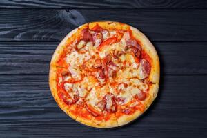 tradicional italiano Pizza en un oscuro antecedentes. comida entrega foto