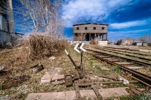 Abandoned railway station . Rusty weathered peeled paint of an old wagon. Blue railway carriage. photo