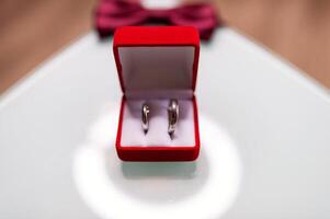 rojo caja con dos dorado Boda anillos en borroso fondo, grande día concepto. casamiento, boda. foto