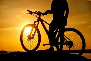 mountain biker silhouette in sunrise. Active Lifestyle Concept photo