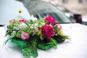 Marriage day composition with pink roses flowers bridal bouquet , wedding flowers viewed from high angle on car background. Burred. Closeup photo