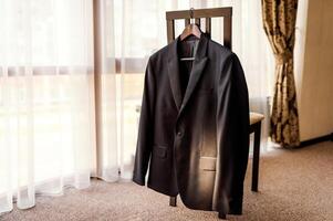 Preparations for the wedding. Groom's jacket on the holder. Wedding photo concept closeup.