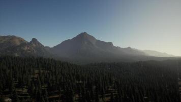 An aerial view of a mountain range with trees in the foreground video