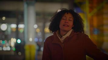 Happy Young Woman with Curly Hair Dancing Outside in the City Night Lights video