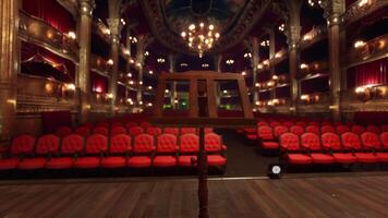 An empty theater with red seats and chandeliers video