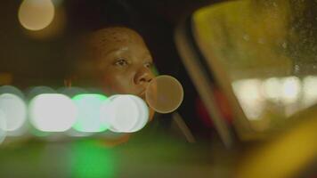 fêmea pessoa com Preto encaracolado cabelo dirigindo carro dentro a cidade às noite tráfego video