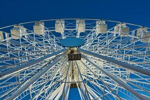 Ferris wheel against a clear blue sky, symmetrical view from below in Lancaster. photo