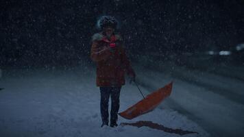 Jeune africain femme permanent sur rue à nuit pendant neige tomber avec parapluie video