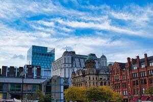 paisaje urbano con un mezcla de moderno y histórico arquitectura debajo un azul cielo con tenue nubes en Manchester, Inglaterra. foto