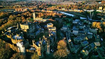 Aerial view of a historic city at sunset with medieval architecture, lush greenery, and a river in Lancaster. photo