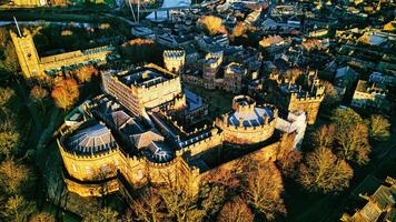 Aerial view of a majestic medieval Lancaster castle at sunset, with surrounding greenery and town in the background. photo