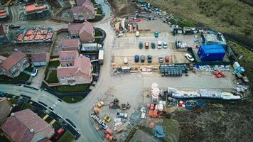 Aerial view of a construction site with materials and equipment near residential houses. photo