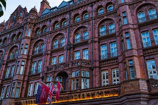 Facade of a grand Victorian building with intricate architecture and warm lighting at dusk in Manchester, England. photo
