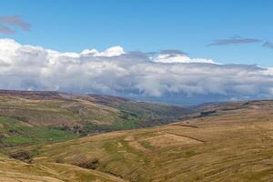 laminación colinas debajo un nublado cielo en un tranquilo rural paisaje en Yorkshire valles. foto