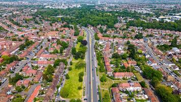 Aerial view of a suburban area with rows of houses and a central road flanked by green spaces in London. photo