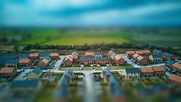 Tilt-shift aerial view of a suburban neighborhood with houses and roads, creating a miniature effect. photo