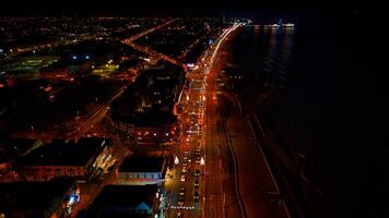 Aerial night view of a coastal city with illuminated streets and dark ocean waters in Backpool, England. photo