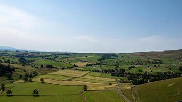 Scenic view of a lush green valley with patchwork fields and a clear sky, ideal for landscape and travel themes. photo