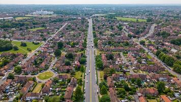 Aerial view of a suburban neighborhood with rows of houses and green trees lining the streets in London. photo