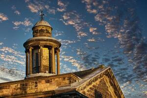 Historic stone building with a dome under a blue sky with scattered clouds at sunset in Lancaster. photo