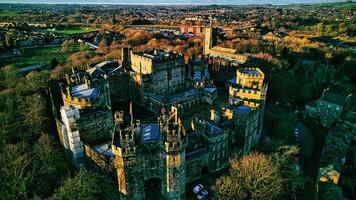 Aerial view of the Lancaster castle surrounded by lush greenery in a quaint town during sunset. photo