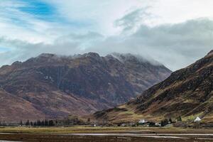 Scenic view of the Scottish mountains in the mist during the winter photo