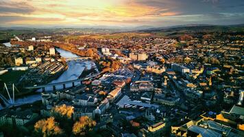 Aerial view of a city Lancaster at sunset with warm lighting, showcasing the urban landscape, buildings, and a river flowing through the center. photo