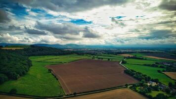 Aerial view of lush green and brown agricultural fields under a dramatic cloudy sky in Yorkshire Moors. photo