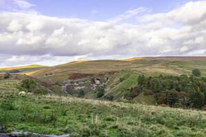 Scenic landscape photo in Yorkshire Dales with clouds over the hills