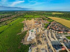 Aerial view of a construction site with residential development in a suburban area, showcasing the contrast between nature and urban expansion. photo